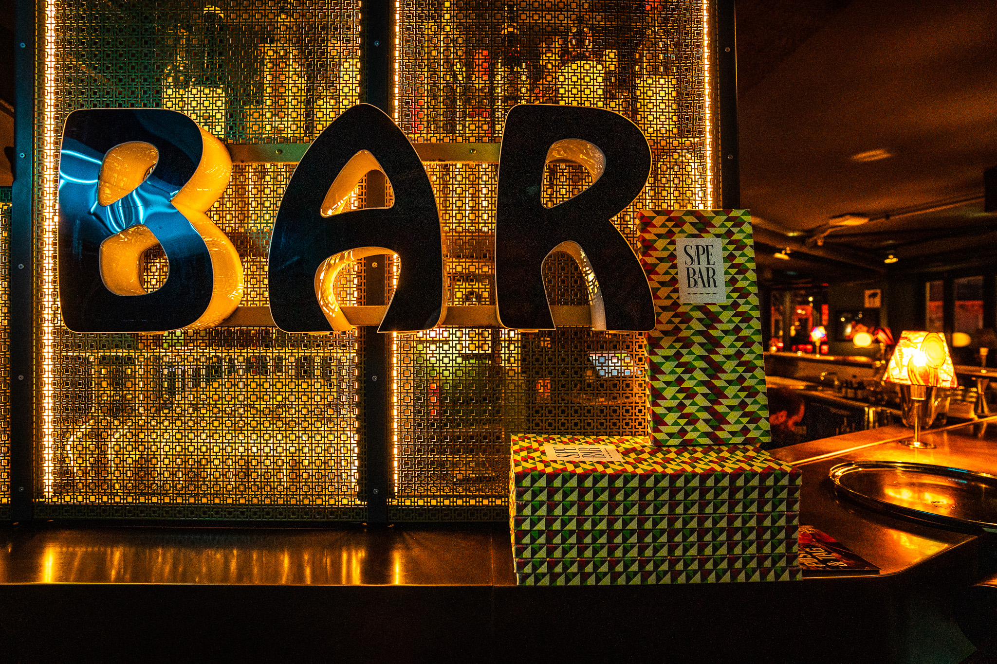 A sign with bold letters spelling out "BAR" at the counter of the Sape Bar