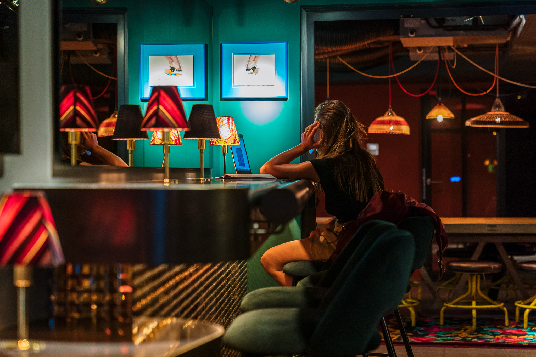 a woman sitting on a bar stool at the counter in the Sape Bar